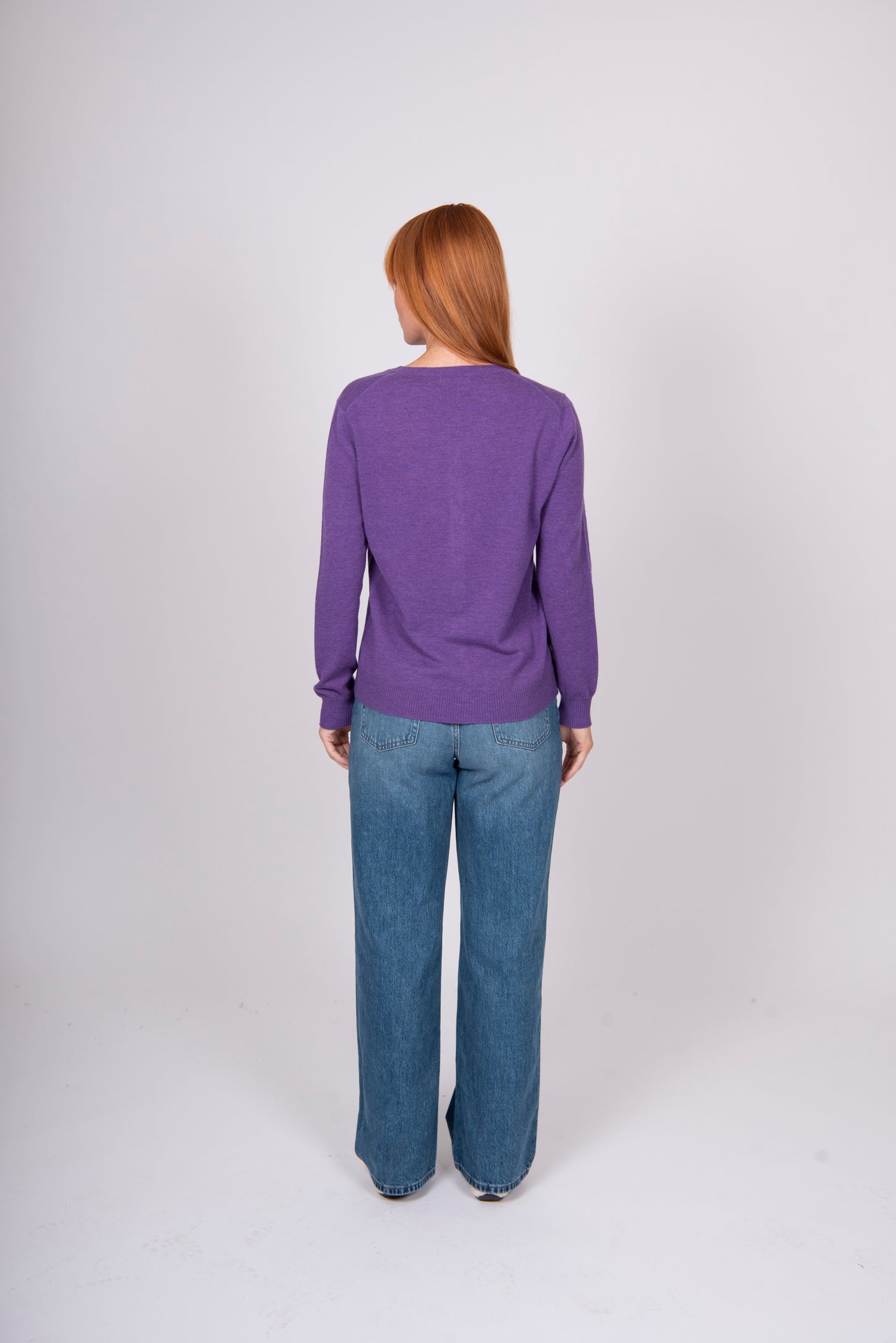 Back view of woman wearing Bridge and Lord's Crew Cardigan in Grape purple