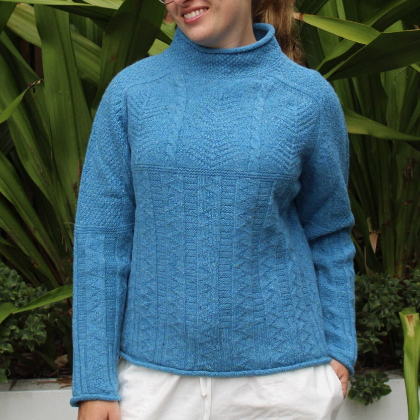 Woman wearing the Aran tunic sweater by Harley of Scotland in Coll blue