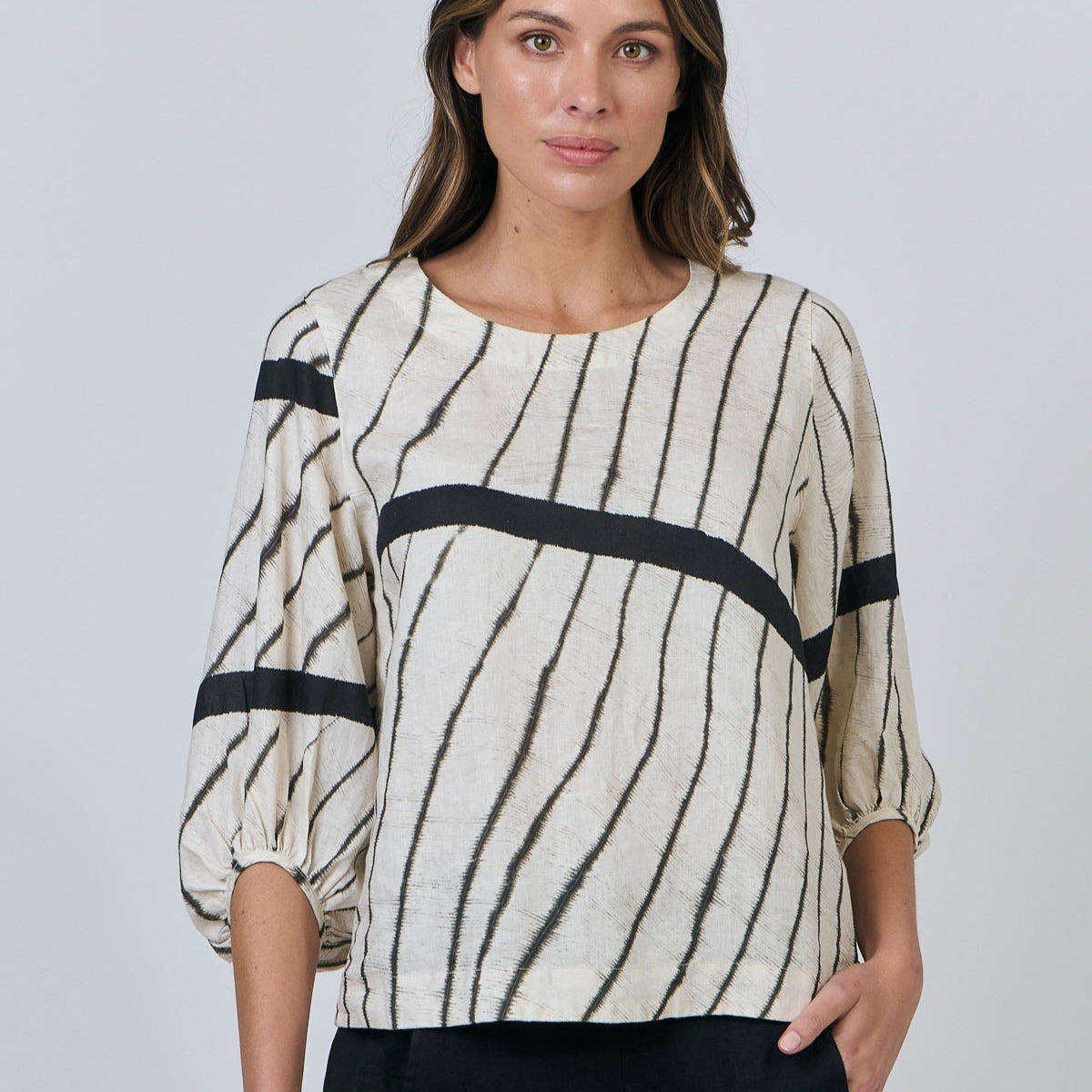 Woman wearing Natural by O&J's Bishop Sleeve Top in Isobars stripe