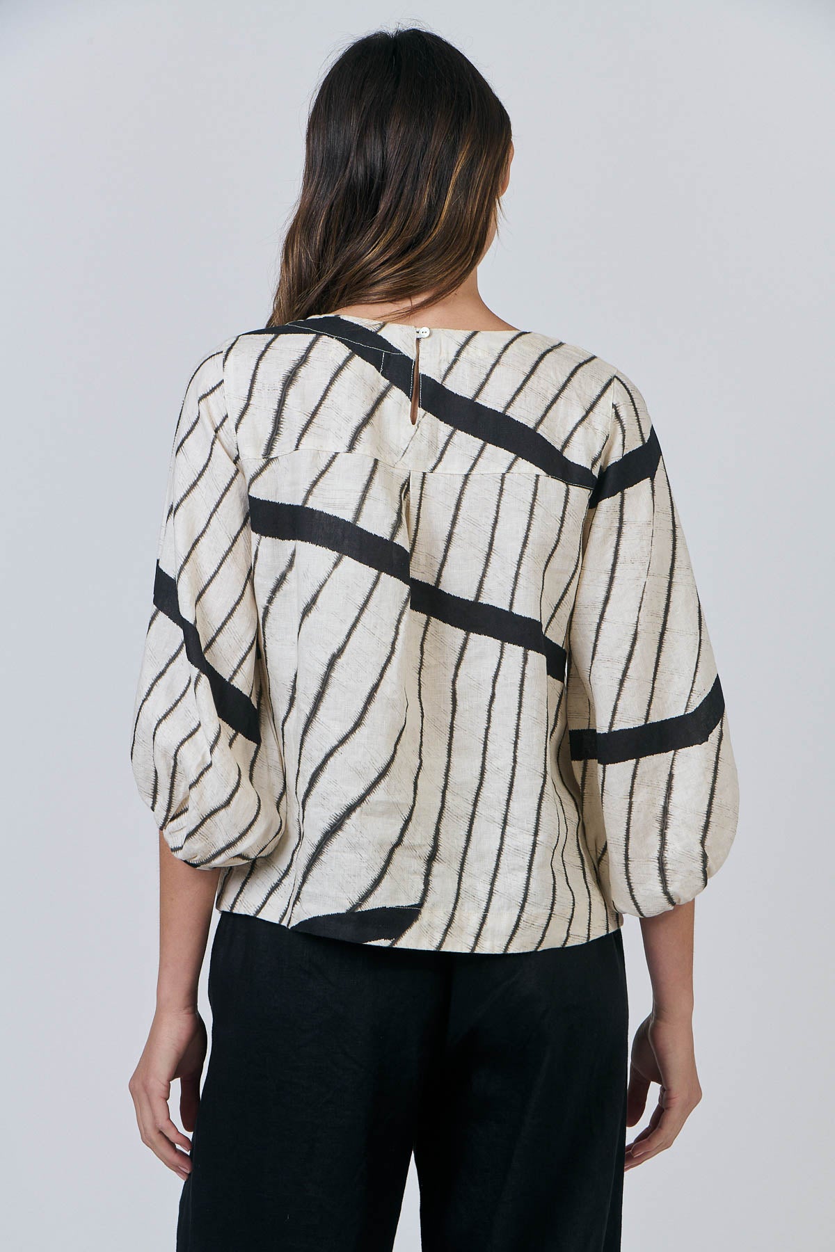 Woman wearing Natural by O&J's Bishop Sleeve Top in Isobars stripe