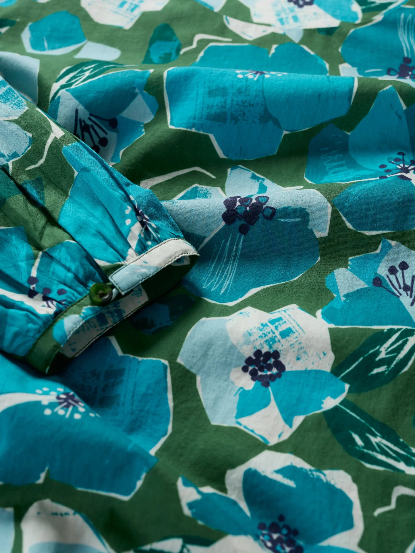 Close up of green and blue floral print of the Quill Top by SEASALT