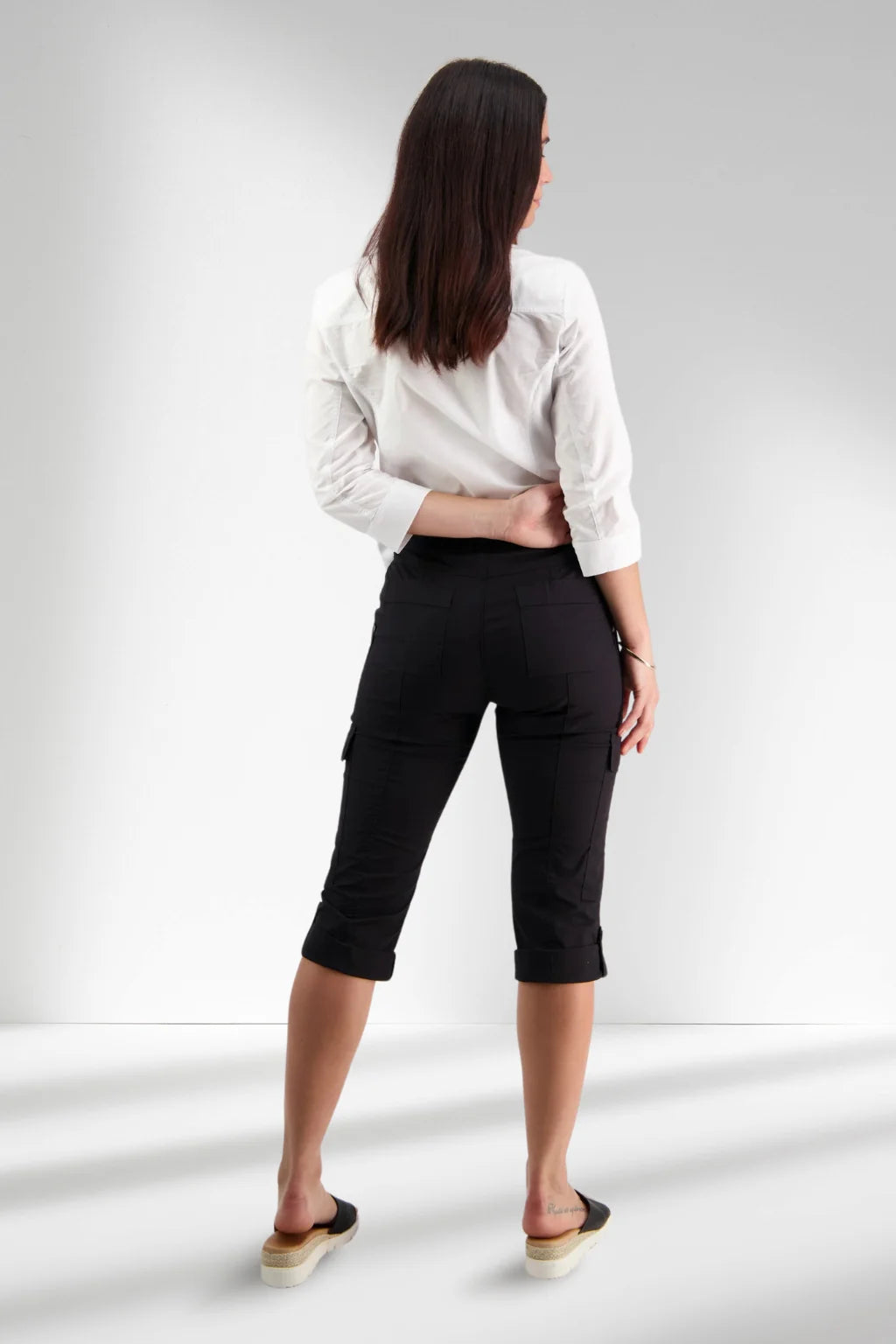 Woman wearing pull on cargo pants in black by vassalli capri length