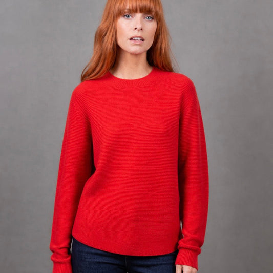 Woman wearing the Bridge and Lord Dolman sleeve red jumper in Cayenne