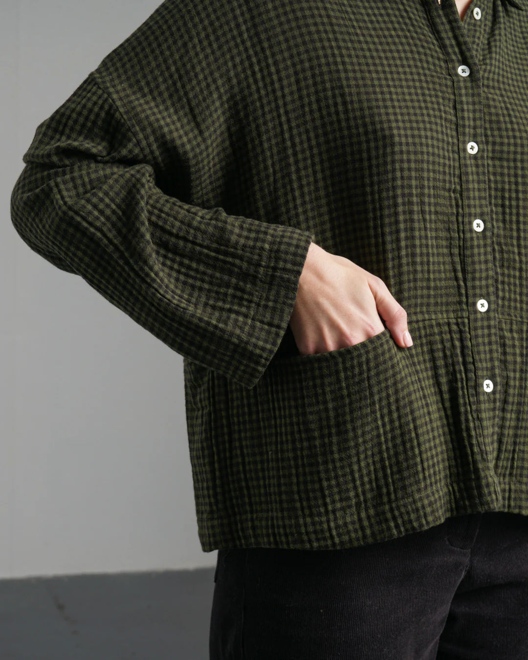 A woman's hand in the pocket of Bibico's Anya Shirt in green check