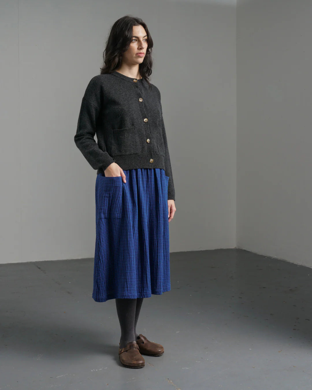 Woman wearing a dark gray cardigan and blue skirt by Bibico