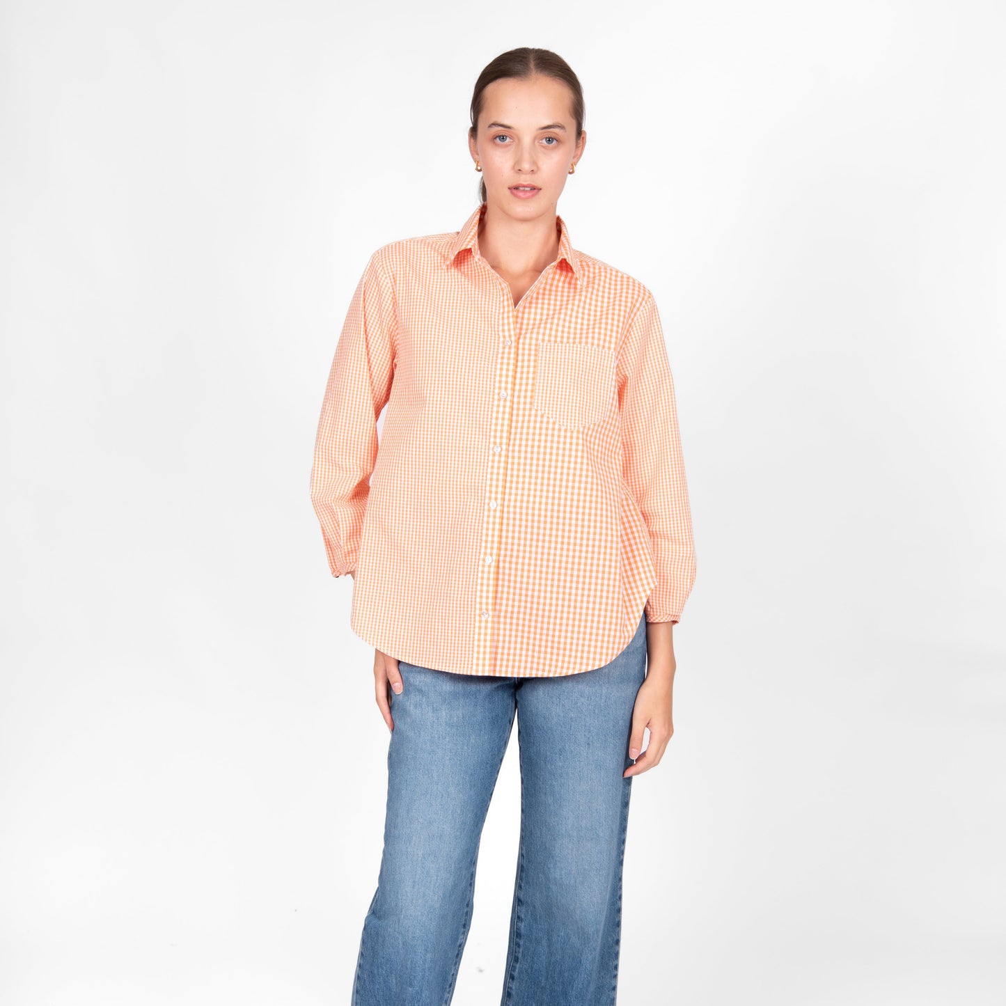 Woman wearing the Bridge and Lord Gingham cotton shirt in Clementine orange