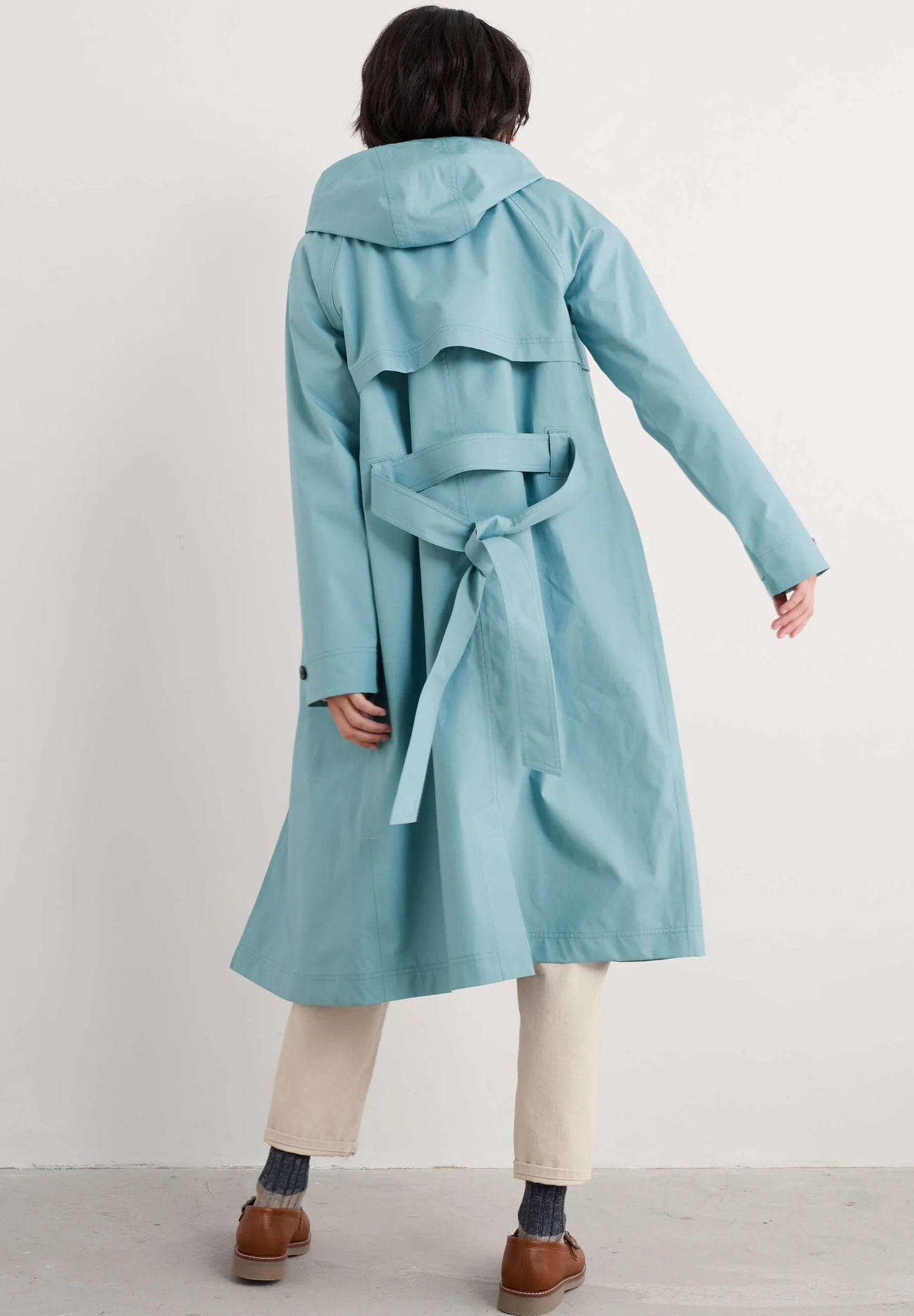 Woman wearing the Penweathers Trench Coat in Hail blue by SEASALT