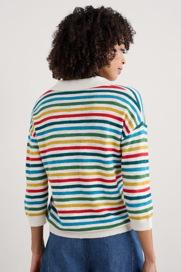 Woman wearing the Gwynver Vee Collar Jumper in multicoloured stripes Mini Cornish Raspberry Multi