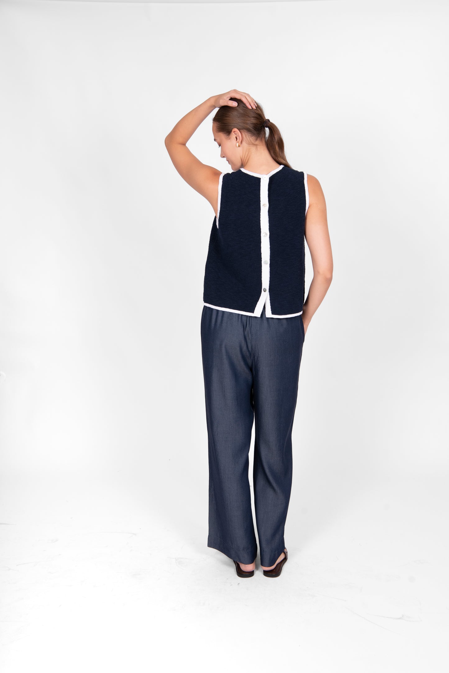Woman wearing the cotton linen Button Back Vest top in navy white by Bridge and Lord