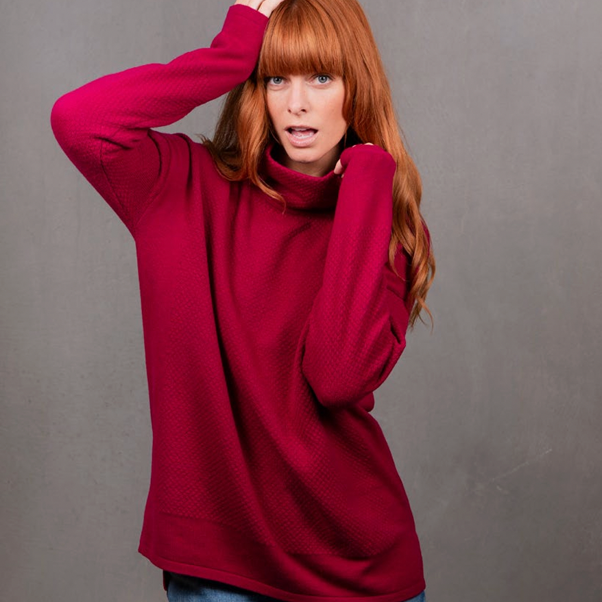 Woman wears the Ball Stitch High Crew Jumper by Bridge and Lord in Cassis red