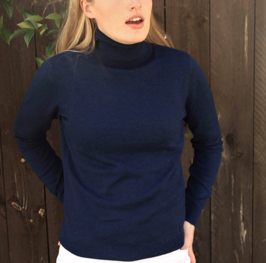 Woman wearing the navy turtleneck top by Bridge and Lord