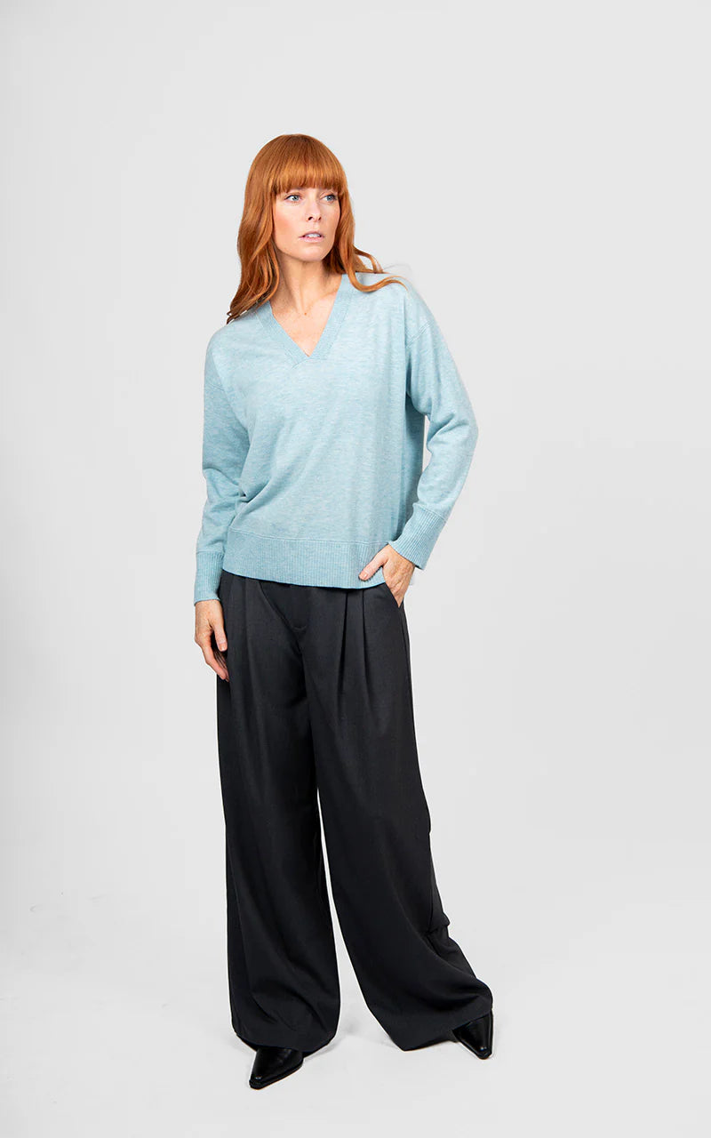 Woman wearing the Bridge and Lord Vee Neck Jumper with trim in Aquamarine blue