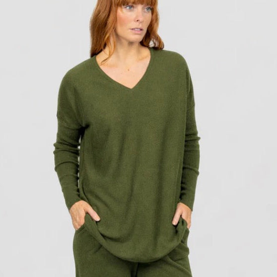 Woman wearing the Olive curved hem vee jumper by Bridge and Lord