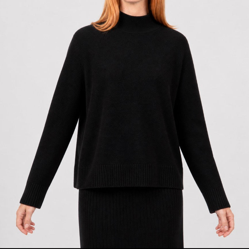 Woman wearing the links ribbed black pullover by Bridge and Lord