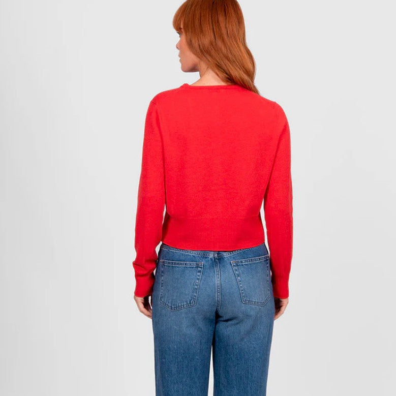 Back view of a woman wearing a cropped red cardigan by Bridge and Lord
