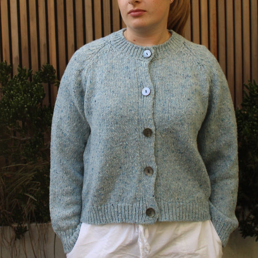 Woman wearing the Fisherman out of Ireland Raglan Merino Cardigan in Blue Mist