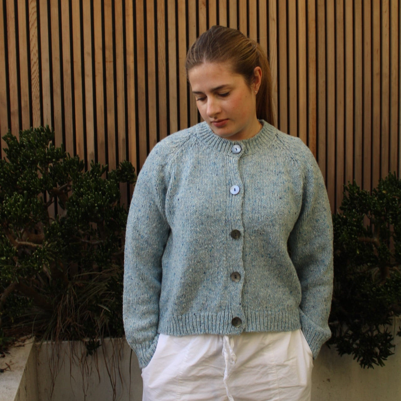 Woman wearing the Fisherman out of Ireland Raglan Merino Cardigan in Blue Mist