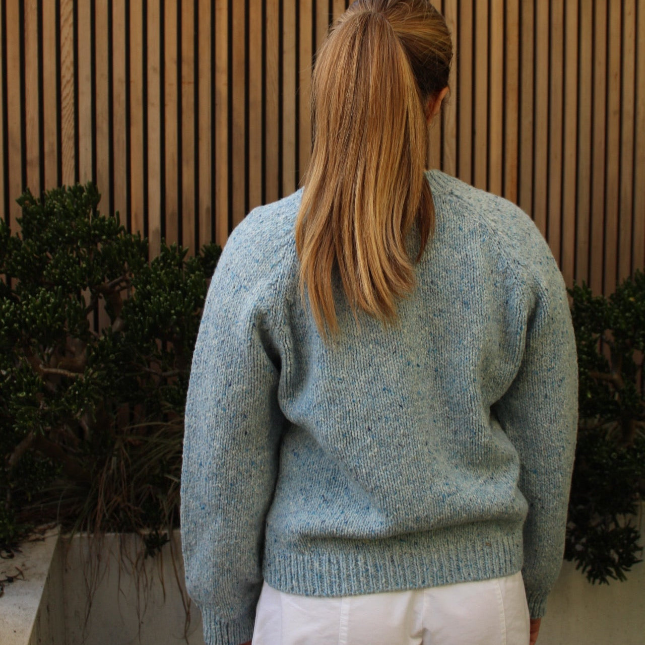 Woman wearing the Fisherman out of Ireland Raglan Merino Cardigan in Blue Mist