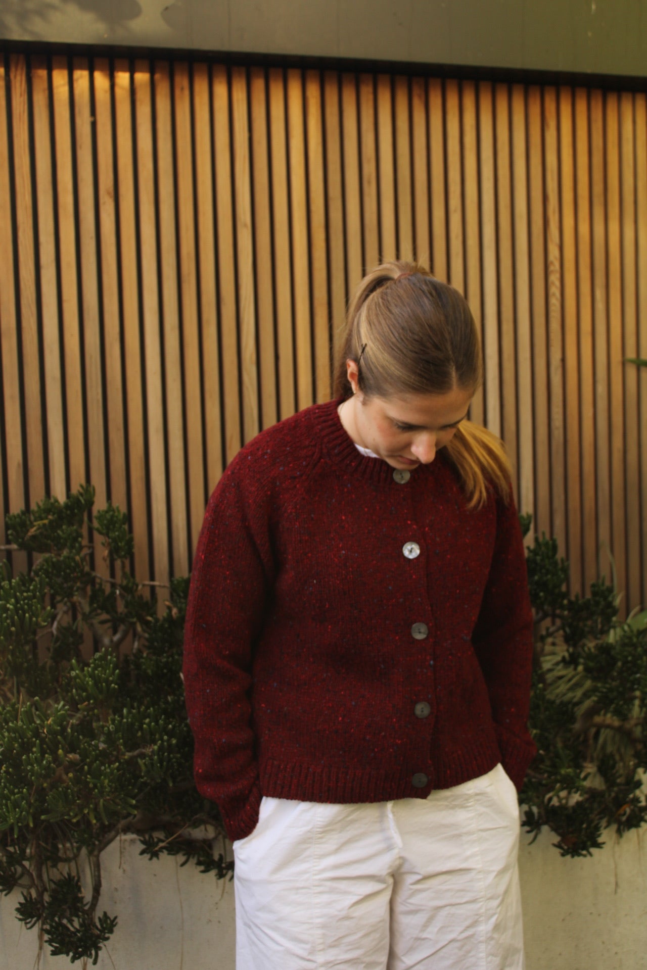 Woman wearing the Fisherman out of Ireland Raglan Merino Cardigan in Cranberry red