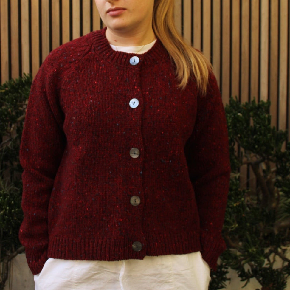 Woman wearing the Fisherman out of Ireland Raglan Merino Cardigan in Cranberry red