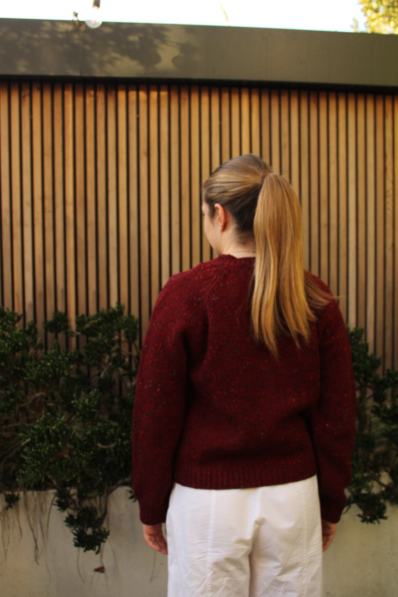 Woman wearing the Fisherman out of Ireland Raglan Merino Cardigan in Cranberry red