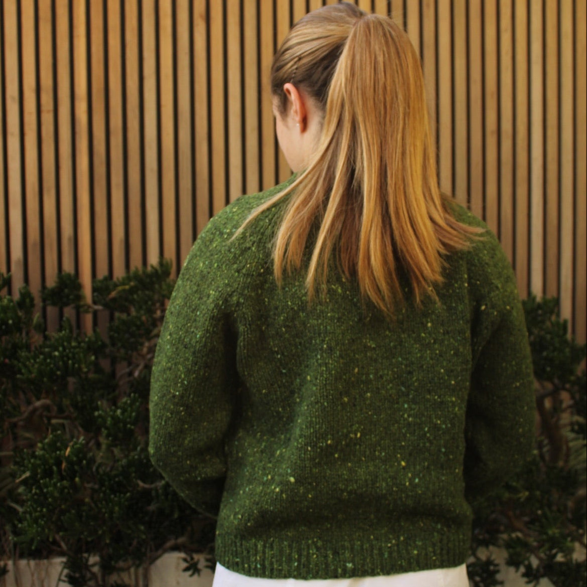 Woman wearing the Fisherman out of Ireland Raglan Merino Cardigan in Shamrock green