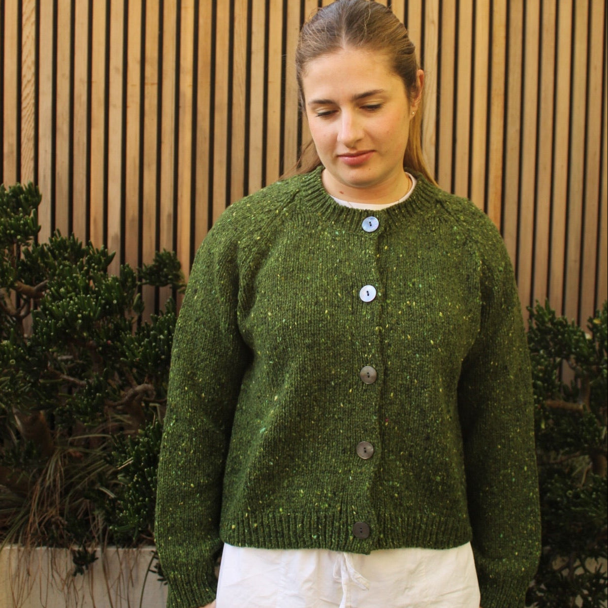 Woman wearing the Fisherman out of Ireland Raglan Merino Cardigan in Shamrock green