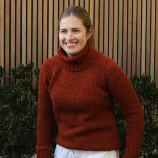 Woman wearing the Fisherman out of Ireland Turtleneck Saddle Jumper in Rust. Australian Merino wool.
