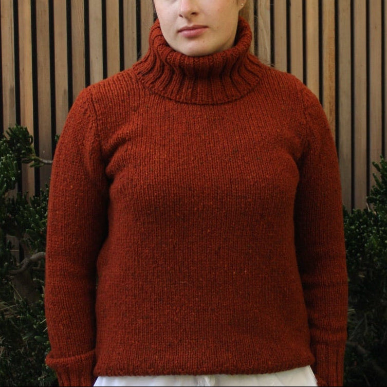Woman wearing the Fisherman out of Ireland Turtleneck Saddle Jumper in Rust. Australian Merino wool.