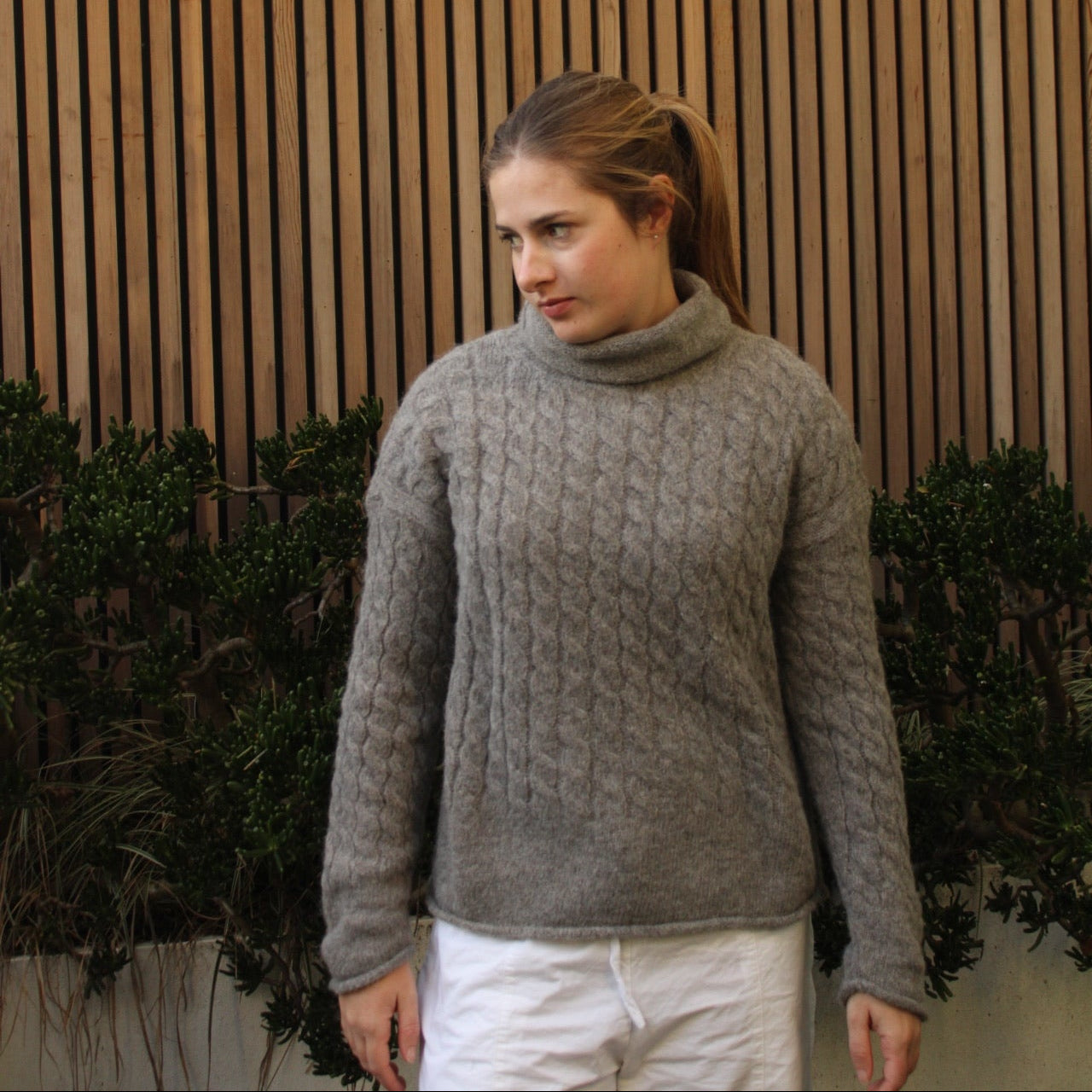 Woman wearing the Fisherman out of Ireland Cable Funnel Neck Jumper in Smoke