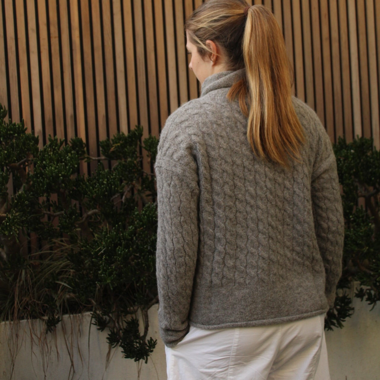 Woman wearing the Fisherman out of Ireland Cable Funnel Neck Jumper in Smoke