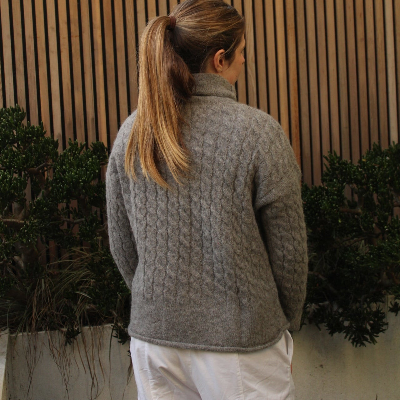 Woman wearing the Fisherman out of Ireland Cable Funnel Neck Jumper in Smoke
