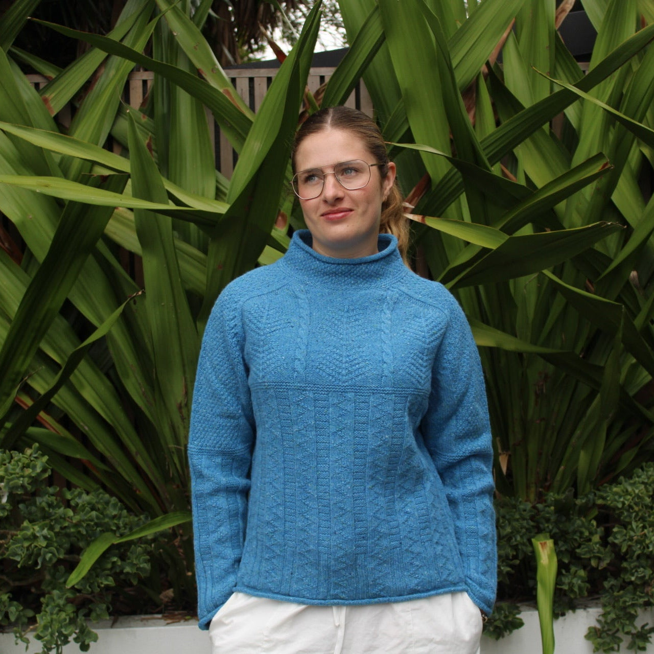 Woman wearing the Aran tunic sweater by Harley of Scotland in Coll blue