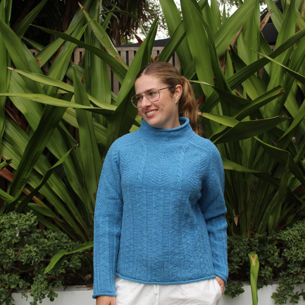 Woman wearing the Aran tunic sweater by Harley of Scotland in Coll blue