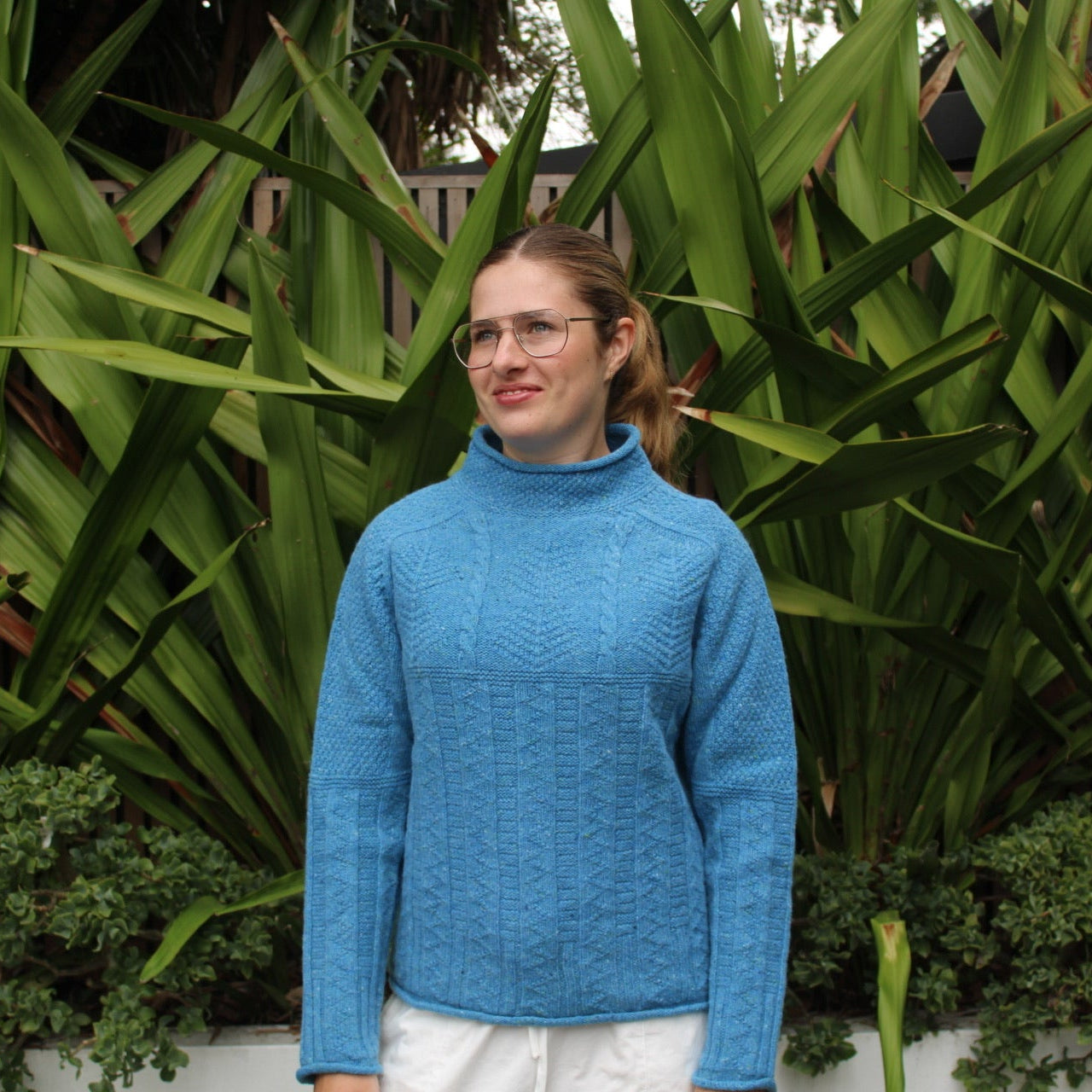Woman wearing the Aran tunic sweater by Harley of Scotland in Coll blue
