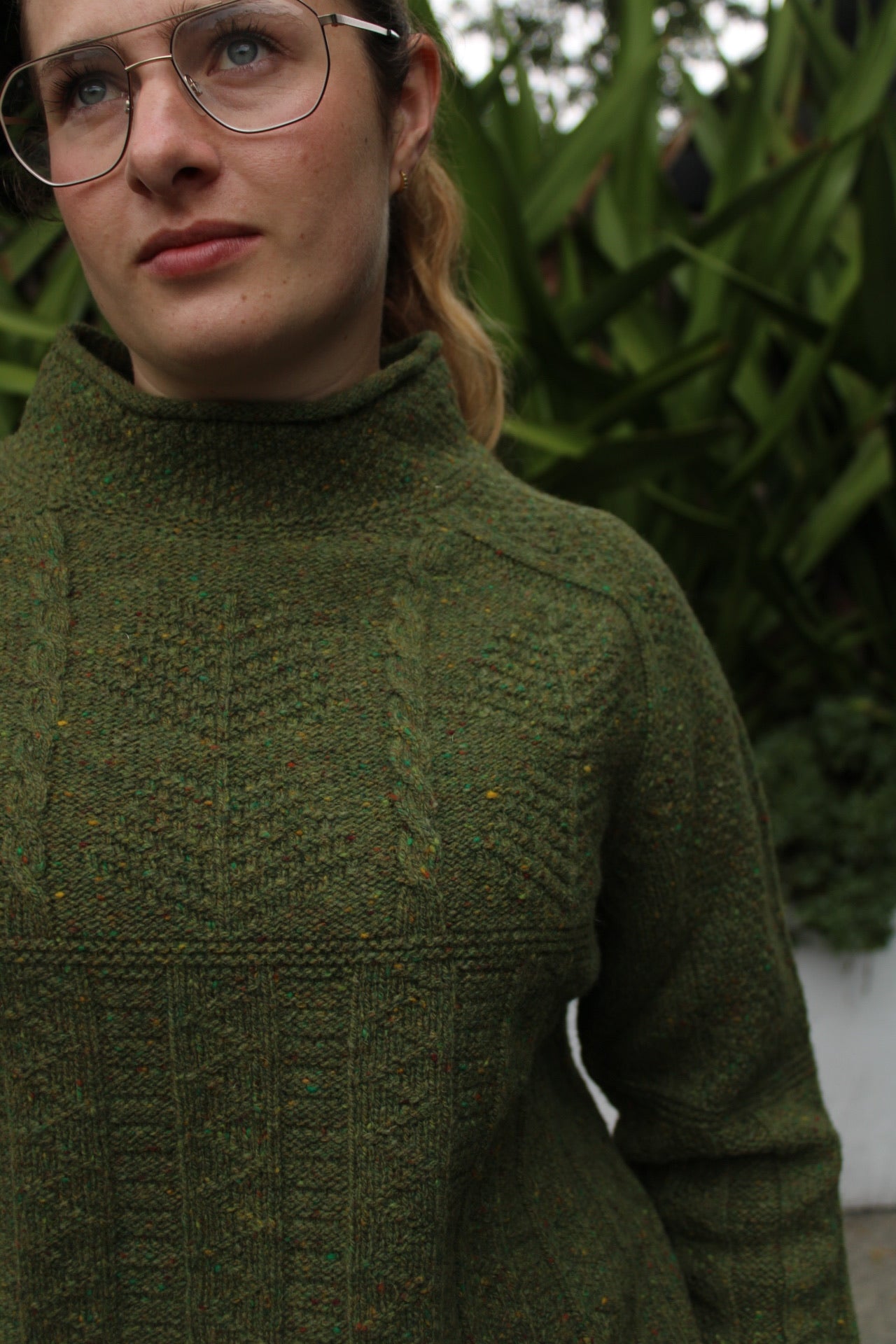 Woman wearing the Aran Tunic sweater by Harley of Scotland in Raasay green