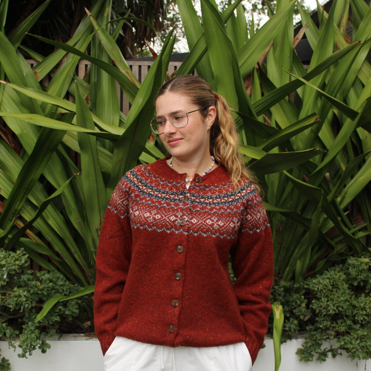 Woman wearing the Chunky Fairisle Nep wool Cardigan in Hoy red by Harley of Scotland