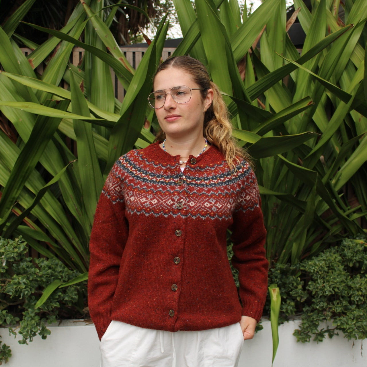 Woman wearing the Chunky Fairisle Nep wool Cardigan in Hoy red by Harley of Scotland