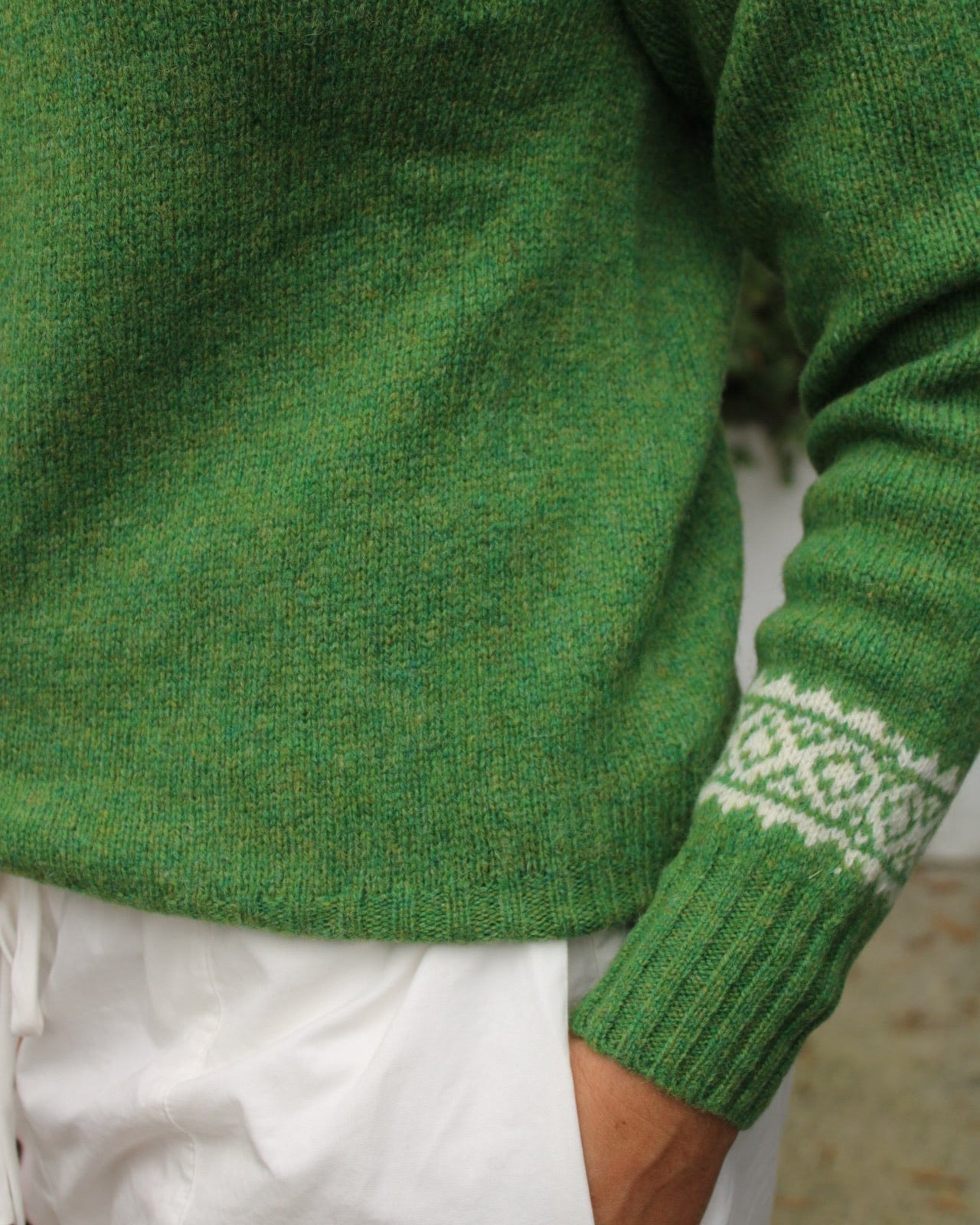 Close-up of a green sweater with a fairisle patterned sleeve