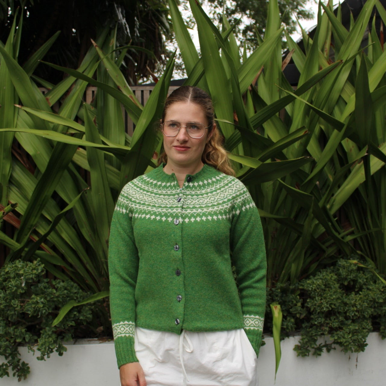 Woman wearing the Two Tone wool Fairisle Cardigan in Blaize green and white by Harley of Scotland