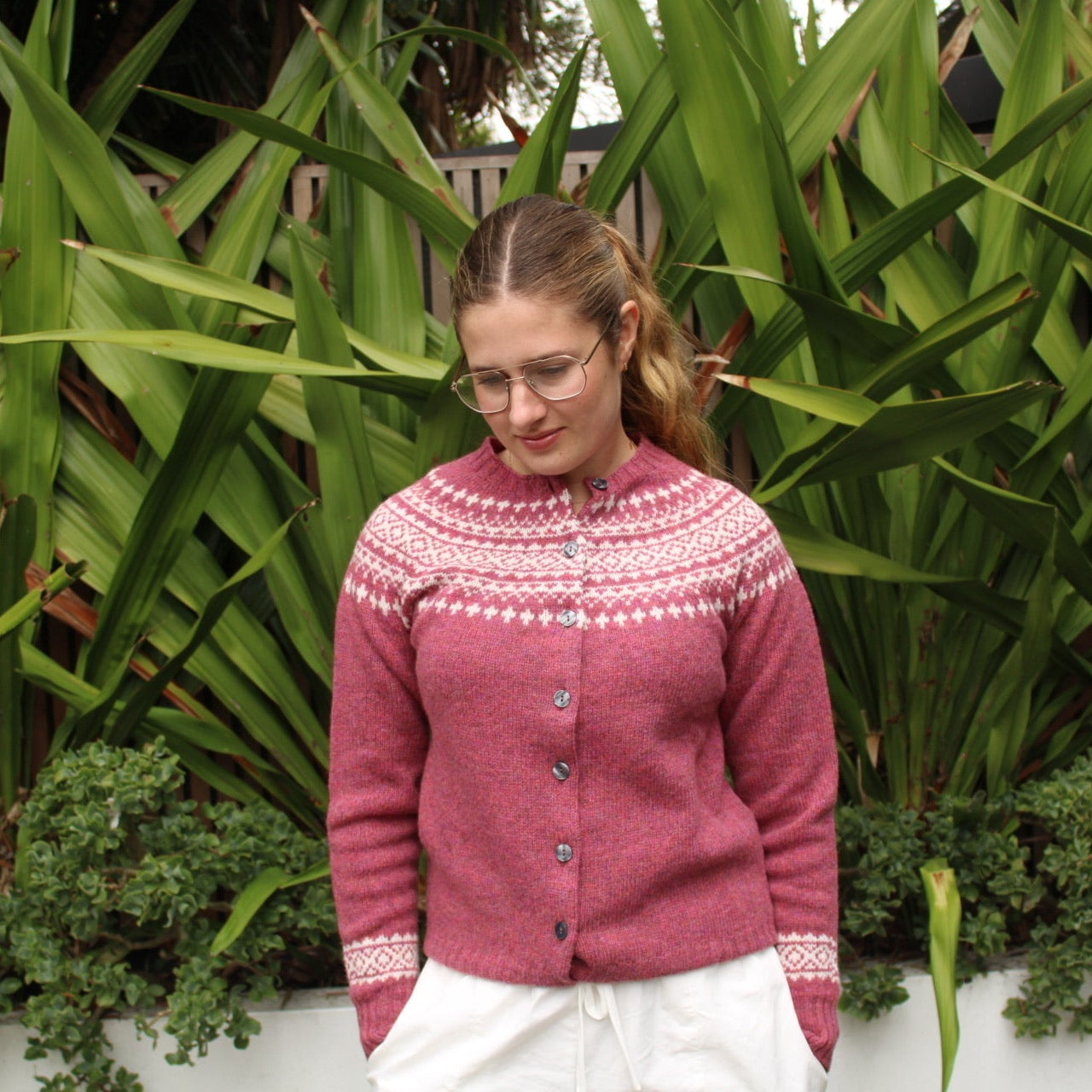 Woman wearing the Two Tone wool Fairisle Cardigan in Zinnia pink and white by Harley of Scotland