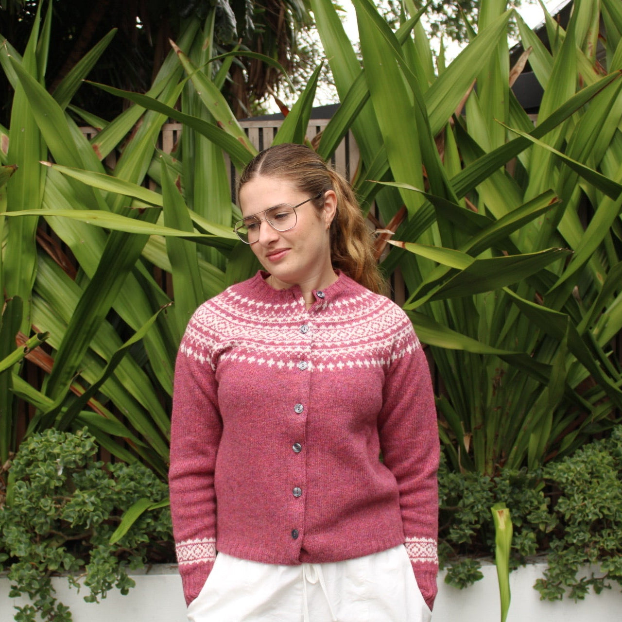 Woman wearing the Two Tone wool Fairisle Cardigan in Zinnia pink and white by Harley of Scotland
