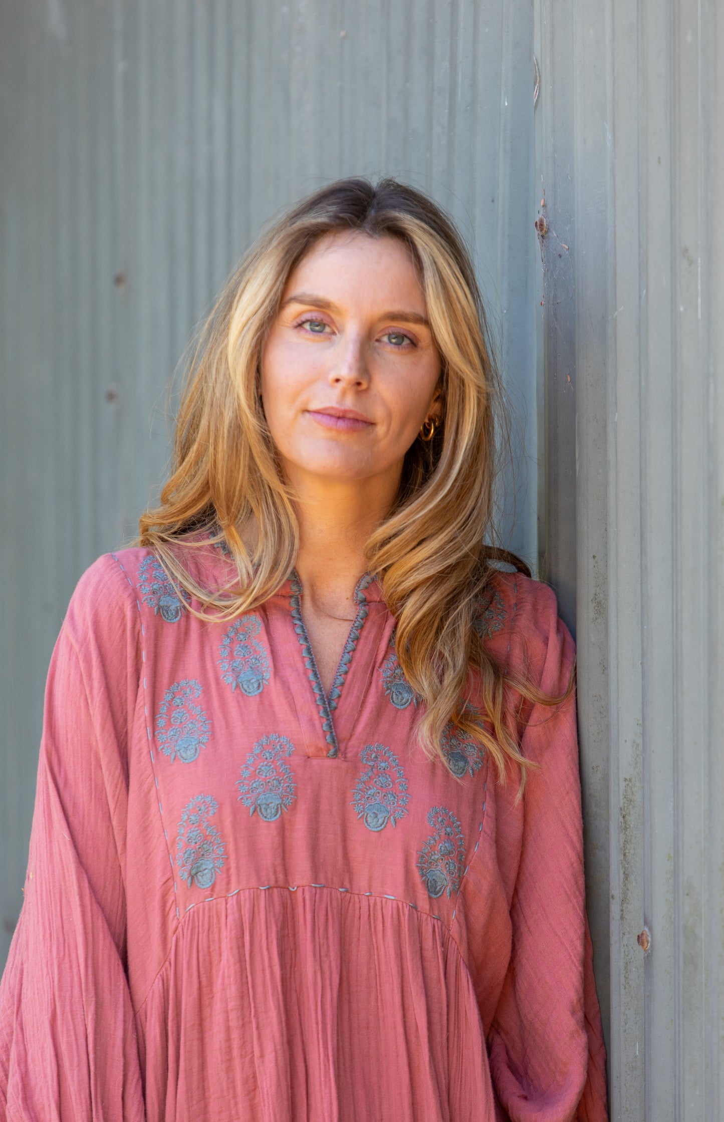 Woman wearing the Mandalay Designs Paisley Souq Dress in Coral