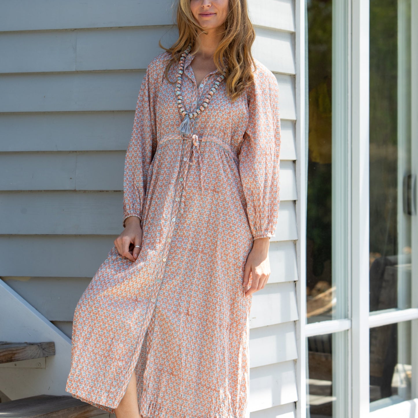 Woman wearing Mandalay Designs by Emma Strauss' Virginia Block print dress in Coral