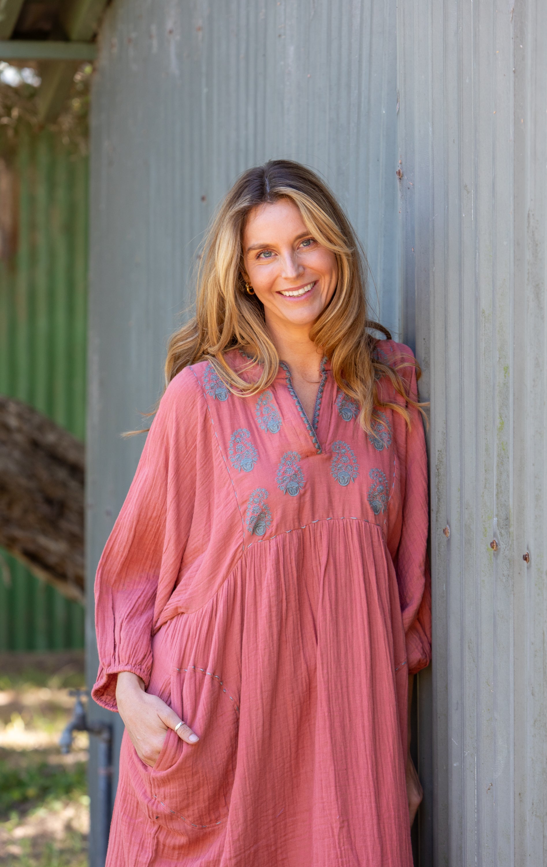 Woman wears the Paisley Souq Dress from Mandalay Designs made from Organic cotton