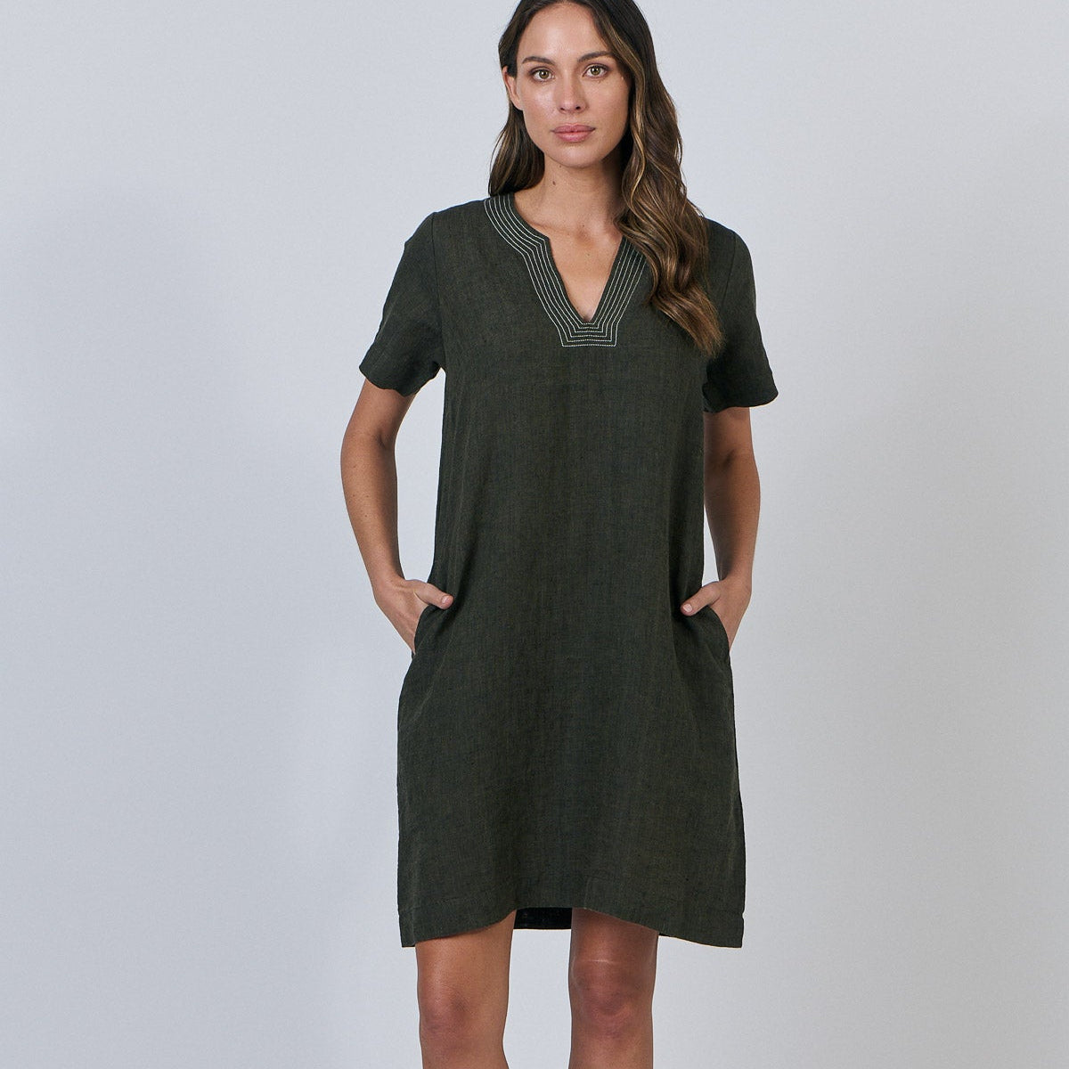 Woman wearing Naturals by O&J's Vee Stitch Linen Dress in Licorice green