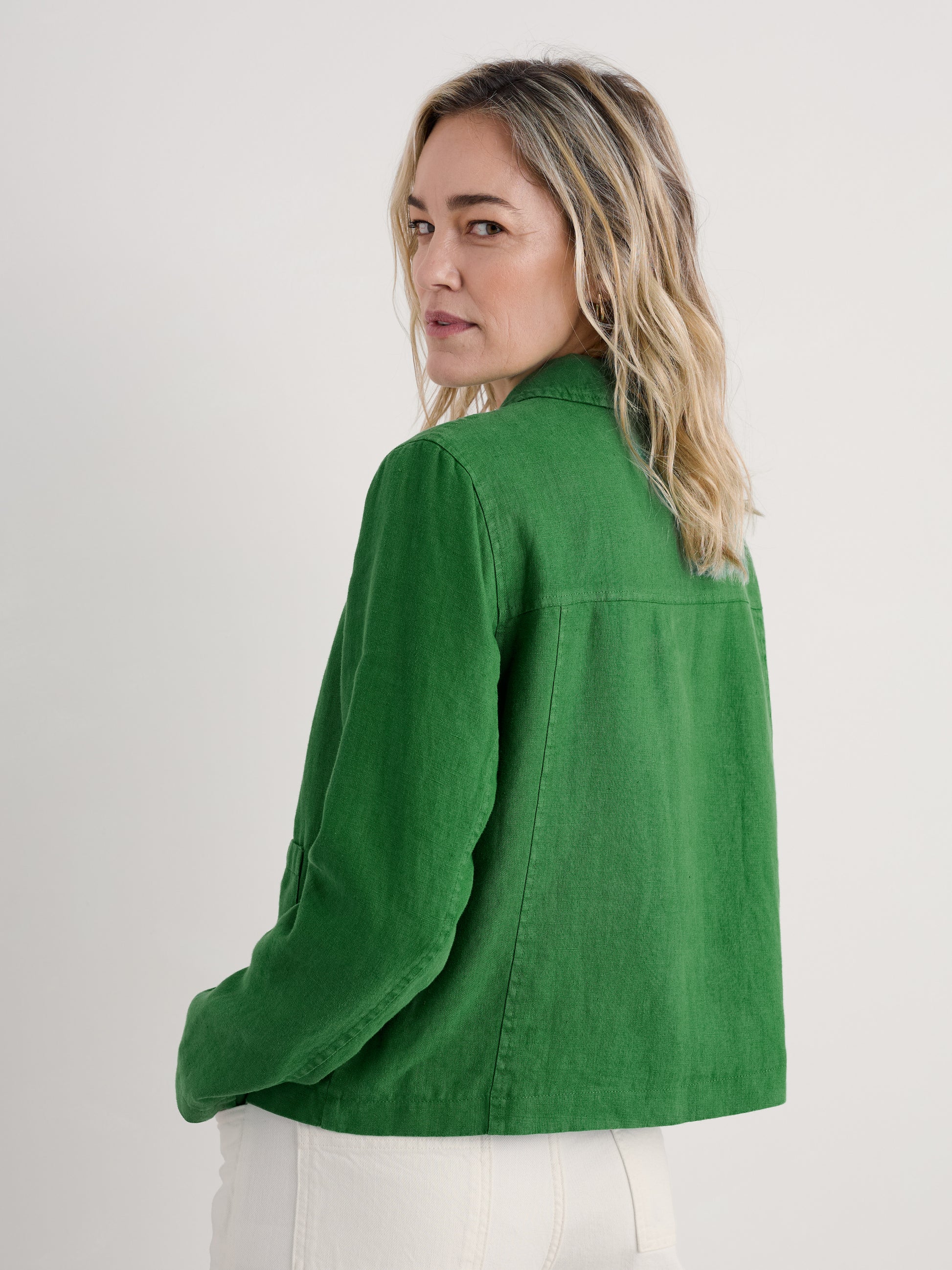 Woman wearing the Arame Linen Jacket in Hedgerow green by SEASALT