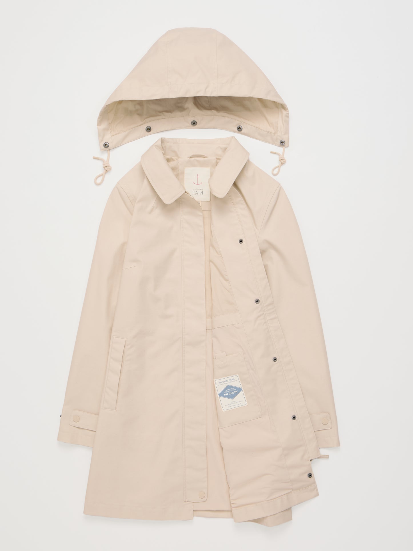 Flat lay of the Cloudburst Mac Raincoat in Limestone with removable hood by SEASALT