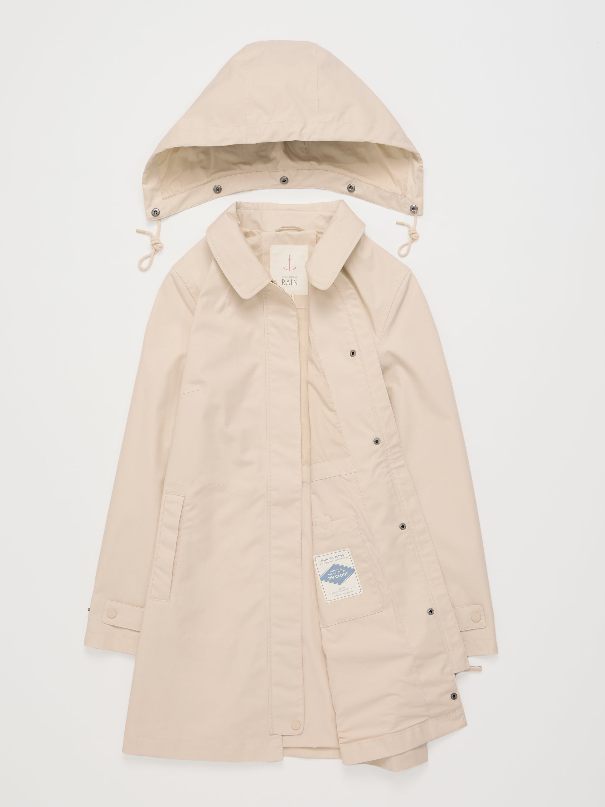 Flat lay of the Cloudburst Mac Raincoat in Limestone with removable hood by SEASALT