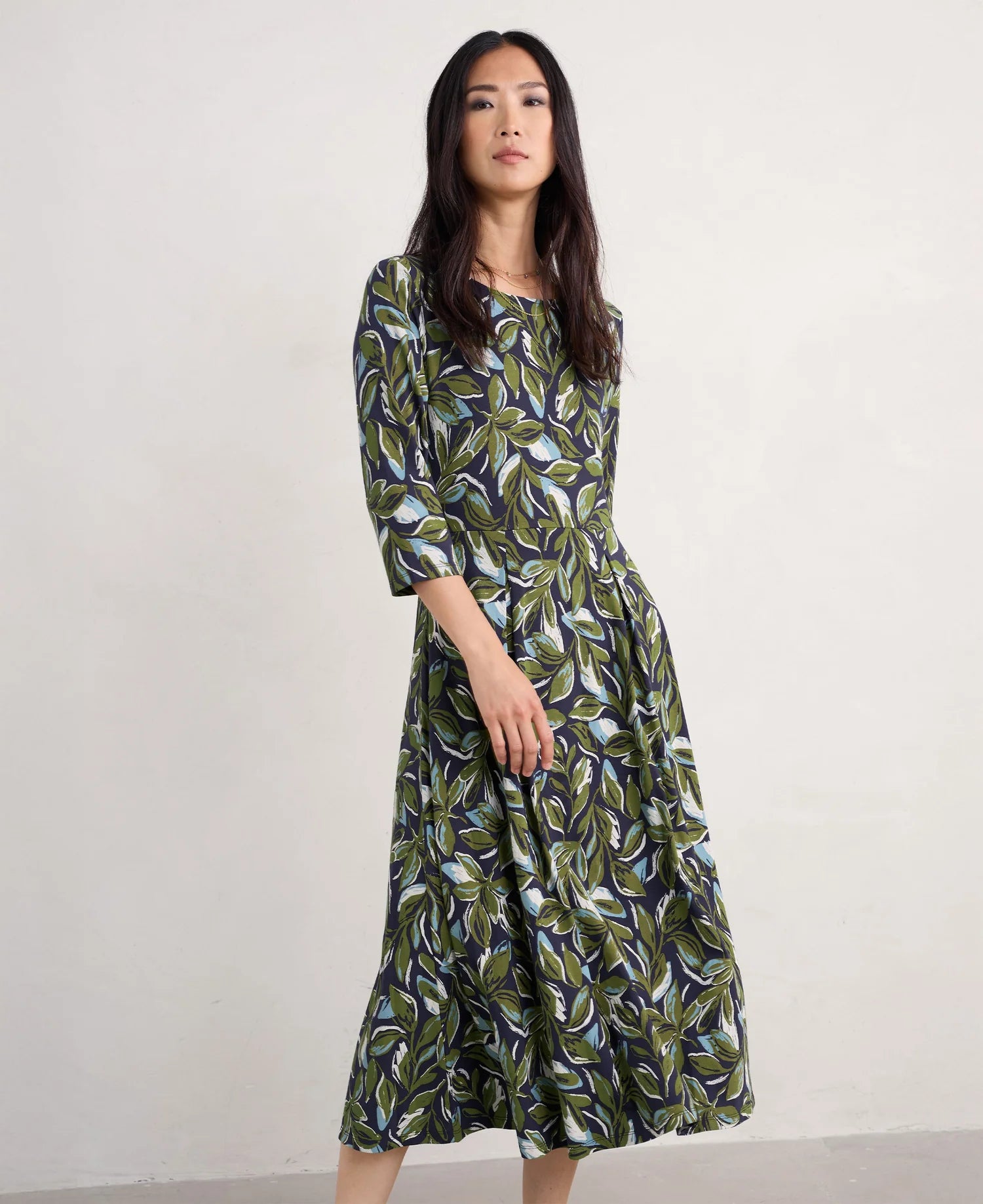 Woman wearing the Wild Bouquet cotton Dress by SEASALT in green Leaves